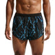 En person iført Nike AeroSwift Printed 2" løbeshorts med underbukser, herre, sort/hvid. Billedet er beskåret, så man kan se personens overkrop og lår mod en ensfarvet baggrund.