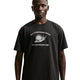 En person har en Nike ACG Dri-FIT T-shirt, herre, sort, på, som er prydet med et hvidt sneglemotiv og teksten »ALL CONDITIONS GEAR FOR OUTDOOR USE« ovenfor og nedenfor. Med den ensfarvede hvide baggrund fremstår denne T-shirt med et rent og moderne look.
