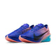Nike Vaporfly Next% 4 til mænd i farvekombinationen Racer Blue/White-Blue Lightning har en overdel med blå farveovergang, lyserød hæl og sål, store sorte Swoosh-logoer samt en lyserød ydersål med struktur, der er inspireret af det originale Vaporfly Next% 4-design.