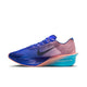 Et billede set fra siden af Nike Vaporfly Next% 4 herresko i farvekombinationen Racer Blue/White-Blue Lightning med en blå overdel, et hvidt Nike-swoosh og en mellemsål i blå farveovergang med teksten »ZOOMX« i hvidt.