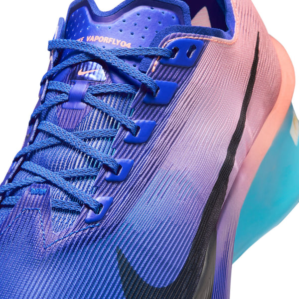 Nærbillede af Nike Vaporfly Next% 4, Herre i farvekombinationen Racer Blue/White-Blue Lightning med en overdel i blå og lilla farveovergang, blå snørebånd, sort Swoosh, lyserød-blå sål og teksten »VAPORFLY 04« tæt på de øverste snørehuller.