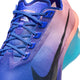 Nærbillede af Nike Vaporfly Next% 4, Herre i farvekombinationen Racer Blue/White-Blue Lightning med en overdel i blå og lilla farveovergang, blå snørebånd, sort Swoosh, lyserød-blå sål og teksten »VAPORFLY 04« tæt på de øverste snørehuller.