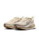 Et par Nike Vomero 18 herresko i farvekombinationen Lt Khaki/Metallic Silver-Desert Khaki, med overdel i mesh, et sølvfarvet Swoosh-logo og tykke hvide såler med lysebrune gummiydersåler, der er designet til maksimal dæmpning. Skoene er afbildet side om side i en let vinkel på en hvid baggrund.