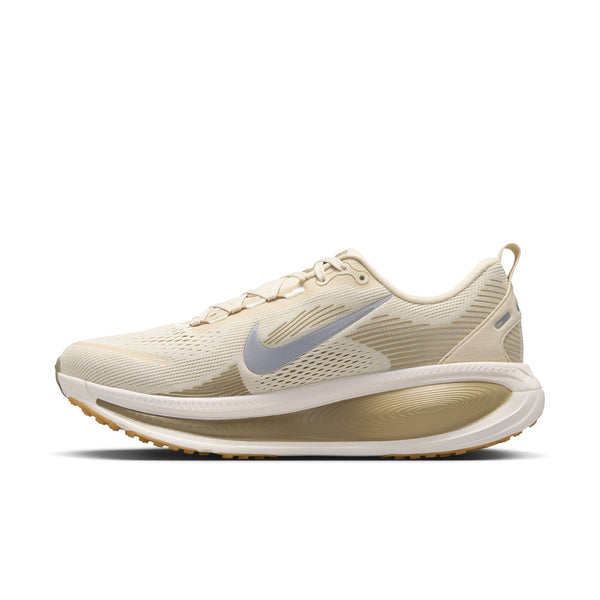 En Nike Vomero 18 herresko i farvekombinationen Lt Khaki/Metallic Silver-Desert Khaki vises set fra siden på en hvid baggrund. Skoen har en beige overdel i mesh, der sikrer god åndbarhed, et sølvfarvet Metallic Swoosh-logo, en hvid sål med en lysebrun ydersål og tilbyder maksimal dæmpning med en synlig luftpude i hælen.