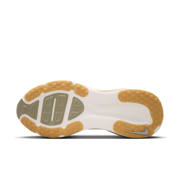 Billedet viser ydersålen på Nike Vomero 18-løbeskoen til herre i farvekombinationen Lt Khaki/Metallic Silver-Desert Khaki. Den overvejende hvide sål har gummi-farvede sektioner og et lille gråt område ved hælen, der er designet til maksimal dæmpning. På hælen ses strukturerede mønstre, der giver godt greb, samt et lille Nike Swoosh-logo.