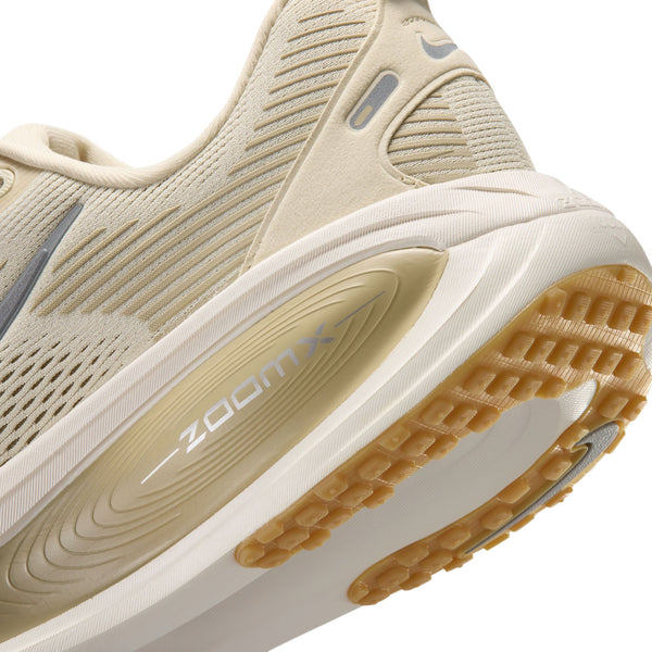 Nærbillede af Nike Vomero 18 herresko i farvekombinationen Lt Khaki/Metallic Silver-Desert Khaki, hvor hælen og sålen fremhæves med ZOOMX-mærket. Skoen er designet som en herreløbesko og giver maksimal dæmpning for enestående komfort. Den brune mønstrede sål sikrer pålideligt greb, mens den netlignende overdel har diskrete grå detaljer, der giver et raffineret look.