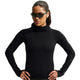 En kvinde iført en sort Nike Wool Running Mid-Layer Top, Dame, sort/sort/sort, med lange ærmer og høj hals samt solbriller.