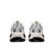 Et par Nike Vomero 18-damesko i farvekombinationen Summit White/Metallic Silver-Sail vises set bagfra, hvor det ikoniske Nike-logo, de åndbare mesh-paneler og de strukturerede såler, der er udviklet til maksimal dæmpning, fremhæves. Skoene er placeret side om side på en ensfarvet hvid baggrund.