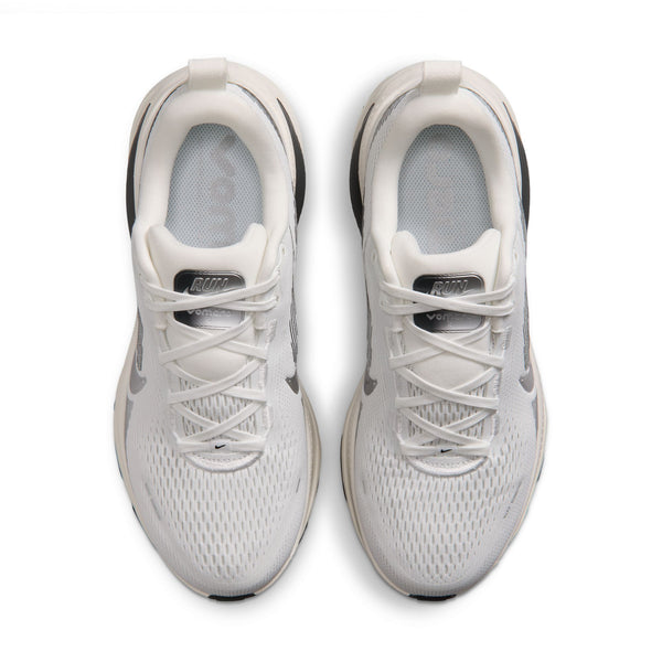 Et par Nike Vomero 18 løbesko til kvinder i farvekombinationen Summit White/Metallic Silver-Sail, set ovenfra. Disse sportssko har maksimal dæmpning, hvide snørebånd og overdel i mesh samt synlige Nike-logoer på tungen og siderne. Sålerne fremstår let off-white.