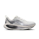 En Nike Vomero 18-løbesko til kvinder i farvekombinationen Summit White/Metallic Silver-Sail, med et metallisk sølvfarvet Nike-swoosh, sorte og grå detaljer på hælen samt »ZoomX«-logoet på den sorte mellemsål. Skoen giver maksimal dæmpning takket være den polstrede overdel i mesh og den slidstærke ydersål i gummi.