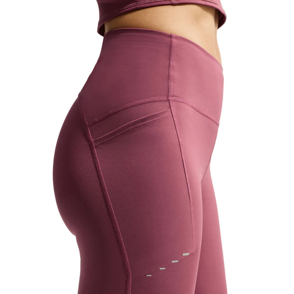 En person har Nikes »High-Waisted 7″ Running Shorts with Pockets, Dame« på i farven Pink Smoke/Reflective Silver – med høj talje, synlige sidesømme, lommedesign inspireret af løbeshorts og reflekterende sølvprikker ved låret; kun den nedre del af overkroppen og de øverste ben er vist.