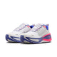 Et par Nike Vomero Plus Dame løbesko i White/Metallic Silver-Concord-Hyper Pink, med tykke såler for komfort, overdel i mesh, snørebånd og Nike swoosh-logoer på siderne.