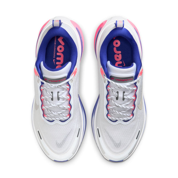 Topbillede af Nike Vomero Plus løbesko til damer i White/Metallic Silver-Concord-Hyper Pink, med lilla og pink accenter, blå indersåler mærket "VOMERO" i pink til højre og hvide snørebånd med grå detaljer for maksimal komfort.