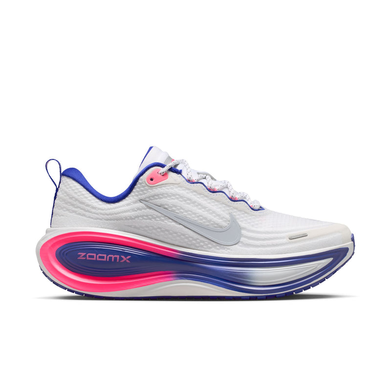 Nike Vomero Plus Dame i White/Metallic Silver-Concord-Hyper Pink har en sølvfarvet swoosh, blå og pink detaljer, en blå ydersål, ZoomX-branding på mellemsålen, trækflig ved hælen og en tekstureret overdel for maksimal komfort.