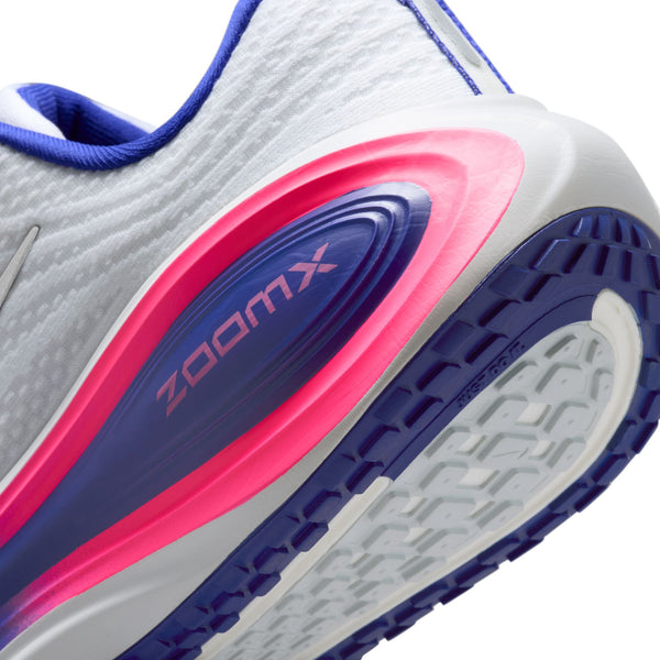 Nærbillede af hælen og sålen på Nike Vomero Plus Dame, White/Metallic Silver-Concord-Hyper Pink, med ZOOMX-branding i pink og blå, hvid overdel, farvet mellemsål og mønstret blå og hvid ydersål for komfort.