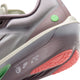 Nærbillede af hælen og siden på den lysviolette Nike Zoom Fly 6 Dame-løbesko i farvekombinationen Lt Violet Ore/Baroque Brown-Sea Glass med grønne og koralfarvede detaljer. Tekst og logoer, herunder »NIKE INTERNATIONAL RUNNING TEAM«, er trykt på sålen.