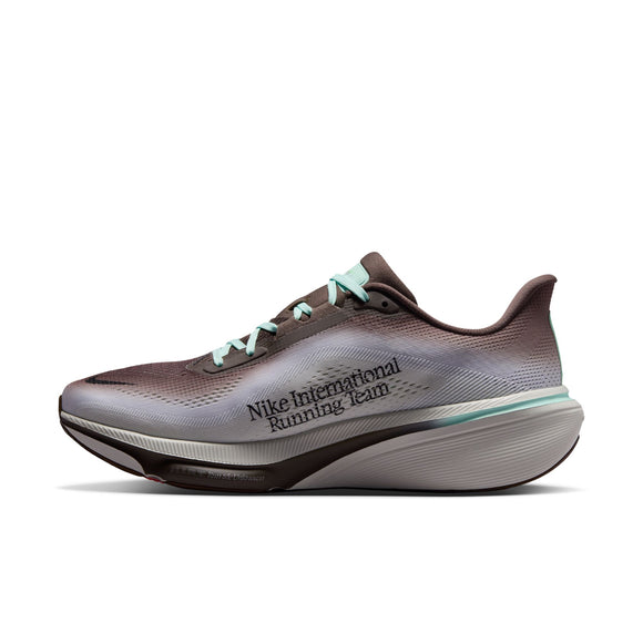 Et billede set fra siden af Nike Pegasus 42 herreløbeskoen i farvekombinationen Ironstone/Black-Sea Glass-Arctic Green, med en overdel i brun og grå farveovergang, mintgrønne snørebånd og teksten »Nike International Running Team« trykt på siden. Skoen er designet med en tyk, hvid og grå polstret sål, der er udstyret med ReactX-skumindlæg for øget komfort.