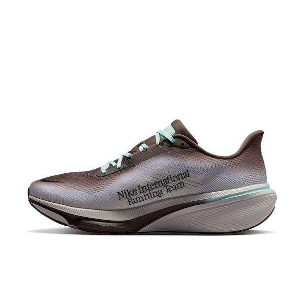 Et billede set fra siden af Nike Pegasus 42 herreløbeskoen i farvekombinationen Ironstone/Black-Sea Glass-Arctic Green, med en overdel i brun og grå farveovergang, mintgrønne snørebånd og teksten »Nike International Running Team« trykt på siden. Skoen er designet med en tyk, hvid og grå polstret sål, der er udstyret med ReactX-skumindlæg for øget komfort.