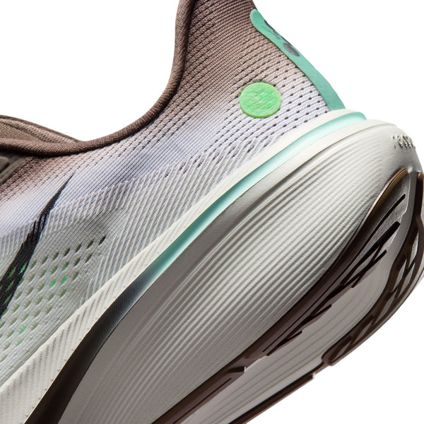 Nærbillede af hælen og sålen på Nike Pegasus 42 Herre i farvekombinationen Ironstone/Black-Sea Glass-Arctic Green, med en hvid og lysegrøn ReactX-skummellemsål i mellemsålen, brun mesh-overdel, synligt mønster på ydersålen og en grøn cirkulær detalje nær hælen.