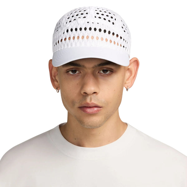 En person, der bærer en hvid Nike ACG Radical AirFlow Fly-kasket med perforerede indsatser.