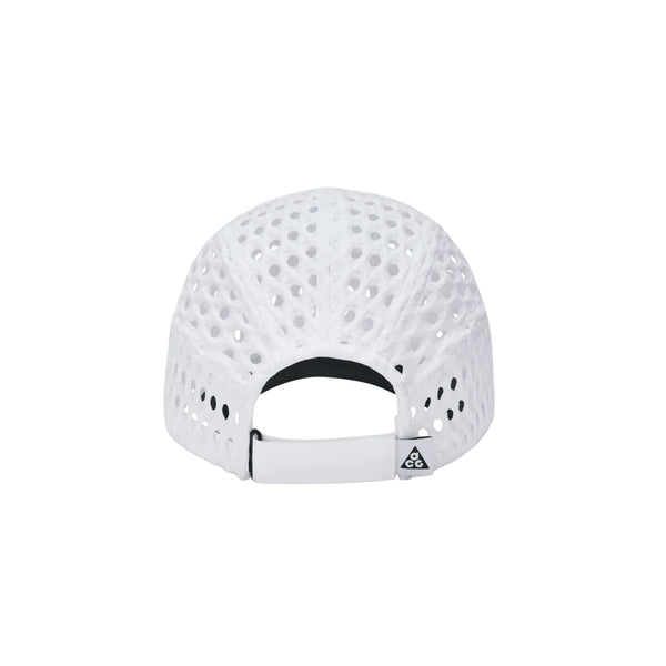 Bagfra set billede af en hvid Nike ACG Radical AirFlow Fly Cap med perforeret design og en justerbar rem med et trekantet logo på lukningen.
