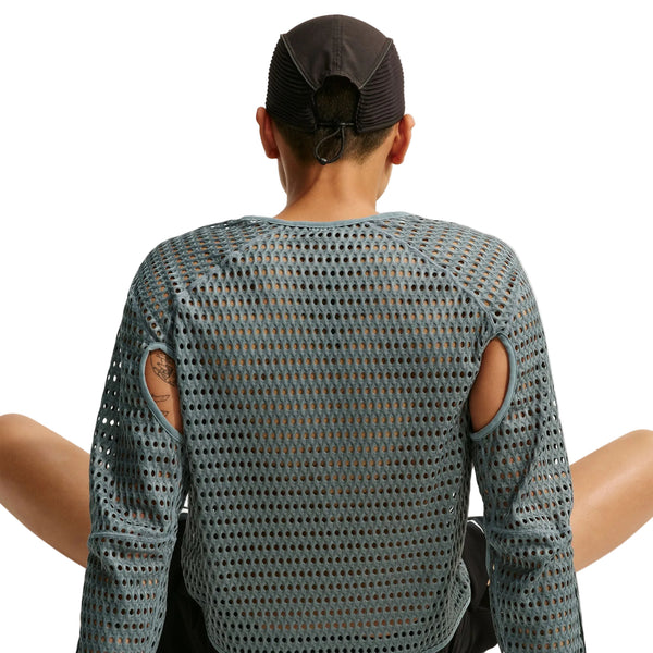 Bagfra-billede af en person, der bærer en grå Nike Stride Aero-FIT langærmet løbetrøje med udskæringer ved skuldrene og en sort kasket.
