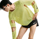 En person iført en limegrøn Stride Aero-FIT langærmet løbetrøje, Herre, Lt Lemon Twist/Black med udskæringer ved albuerne og sorte sportsshorts.