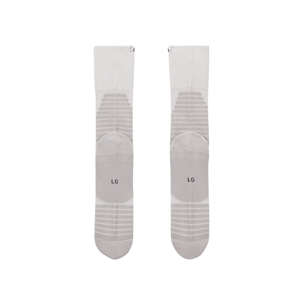 Et par Nike ACG Crew Socks, unisex i Summit White/Lt Smoke Grey med polstrede sektioner og M/L-størrelsesmarkeringer nær tæerne, vist fladt side om side på en hvid baggrund.