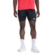 En person iført en rød trøje, sorte Adidas Adi365 Adaptive Running Half Tights til mænd, hvide strømper og hvide sneakers står foran en ensfarvet hvid baggrund. Ansigtet og overkroppen er ikke synlige.