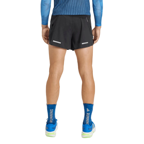 En person, der står med ryggen til, iført en blå langærmet trøje, Adidas Adi365 Climacool+ Pocket Shorts (herre, sort), blå sokker med teksten »RUNNING« og hvide løbesko med grønne og blå detaljer. Fokus er på benene og lænden, hvilket fremhæver et adidas-løbetræningslook.