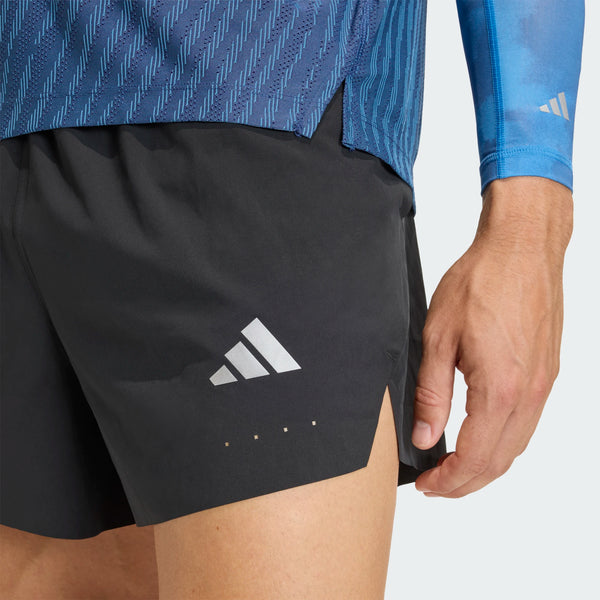 En person har Adidas Adi365 Climacool+ Pocket Shorts, Herre, i sort på – perfekte til adidas-løbetræning – hvor kun den nedre del af overkroppen og højre hånd er synlige. Shortsene er forsynet med det karakteristiske Adidas-logo og er kombineret med en blå skjorte med matchende ærmer, hvilket fremhæver disse stilfulde løbeshorts til mænd.