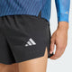 En person har Adidas Adi365 Climacool+ Pocket Shorts, Herre, i sort på – perfekte til adidas-løbetræning – hvor kun den nedre del af overkroppen og højre hånd er synlige. Shortsene er forsynet med det karakteristiske Adidas-logo og er kombineret med en blå skjorte med matchende ærmer, hvilket fremhæver disse stilfulde løbeshorts til mænd.