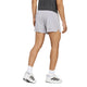 En person står med ryggen til, iført en sort T-shirt og Adidas Adi365 Climacool+ Pocket Shorts, Herre, Glogry – lysegrå shorts designet med fokus på åndbarhed. Hvide sokker og hvide sneakers med sorte striber fuldender looket på en ensfarvet hvid baggrund.
