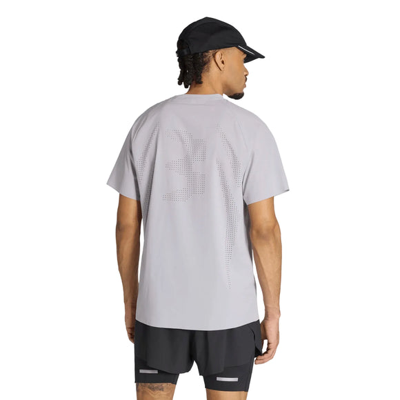 En person iført en Adidas Adi365 Running Aspyre T-shirt, Herre, Glogry med et perforeret talmønster på ryggen, sorte shorts med reflekterende detaljer og en sort kasket, set bagfra.