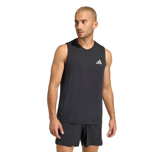 En mand med kort blondt hår har en Adidas Adi365 Running Essentials Tank, Herre, Sort på – en uundværlig letvægts løbetrøje – samt matchende sorte shorts, og han står foran en ensfarvet hvid baggrund.