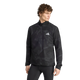 En person med krøllet hår står foran en ensfarvet hvid baggrund iført en Adidas Adi365 Running Half Zip langærmet trøje til mænd i farven Black/Grefiv, der har et hvidt adidas-logo på brystet, samt matchende sorte leggings.