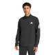 En person står med ansigtet fremad og har den sorte Adi365 Running Iconc Half Zip herre-trøje fra Adidas på. Denne langærmede trøje har en kvart lynlås og er prydet med hvide Adidas-logoer på brystet og ærmerne. Den ensfarvede hvide baggrund fremhæver denne stilfulde løbetrøje til mænd.