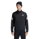 En mand står foran en ensfarvet hvid baggrund iført Adidas Adi365 Running Iconic-jakken, herre, sort, som er prydet med karakteristiske hvide Adidas-logoer og striber på ærmerne. Han kombinerer denne løbejakke med sorte bukser og en sort strikket hue, hvilket skaber et sporty og samtidig klassisk look, der forener både stil og komfort.