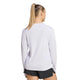 En kvinde med langt blondt hår sat op i en hestehale ses set bagfra iført en Adidas Adi365 Running Iconic langærmet trøje (Dame, Fropur/Hvid) og sorte shorts foran en ensfarvet hvid baggrund.