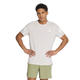 En person står med hænderne i siden og har en Adidas Adi365 Running Iconic T-shirt til mænd i farven Greone/White på, der er prydet med Adidas-logoet og de karakteristiske hvide striber på ærmerne, kombineret med lysegrønne shorts. Baggrunden er ensfarvet hvid.