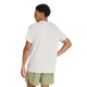 En person står med ryggen til og har en Adidas Adi365 Running Iconic T-shirt til mænd i farven Greone/White på samt lysegrønne shorts. Baggrunden er ensfarvet hvid, og personens venstre arm er bøjet, mens hånden hviler på hoften.