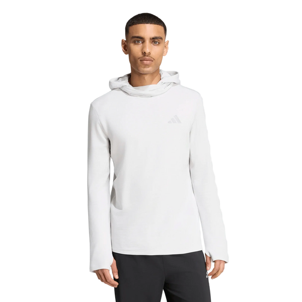 En mand står med ansigtet vendt fremad iført en enkel hvid Adidas Adi365 Running Winterized Long Sleeve-trøje (herre, grøn) med lange ærmer og sorte bukser, foran en hvid baggrund. Denne Adidas-trøje er udstyret med Climawarm-teknologi, der sikrer, at du holder dig varm i køligere vejr.