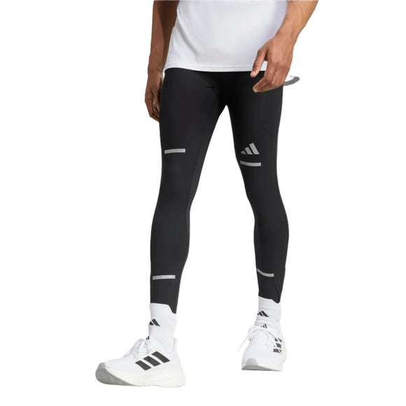 En person iført hvid t-shirt, Adidas Adi365 Tights M (Herre, Sort), hvide strømper og hvide Adidas-sneakers står på en almindelig hvid baggrund.