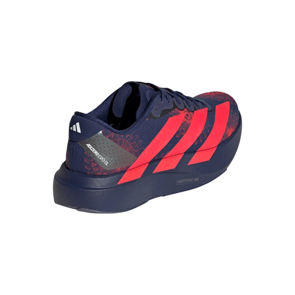 Adidas Adizero Evo SL Woven til kvinder i mørkeblå med knaldrøde striber har en mønstret overdel, mørk sål, Lightstrike Pro- og Adizero Adios-tekst på siden og et lille hvidt Adidas-logo på hælen.