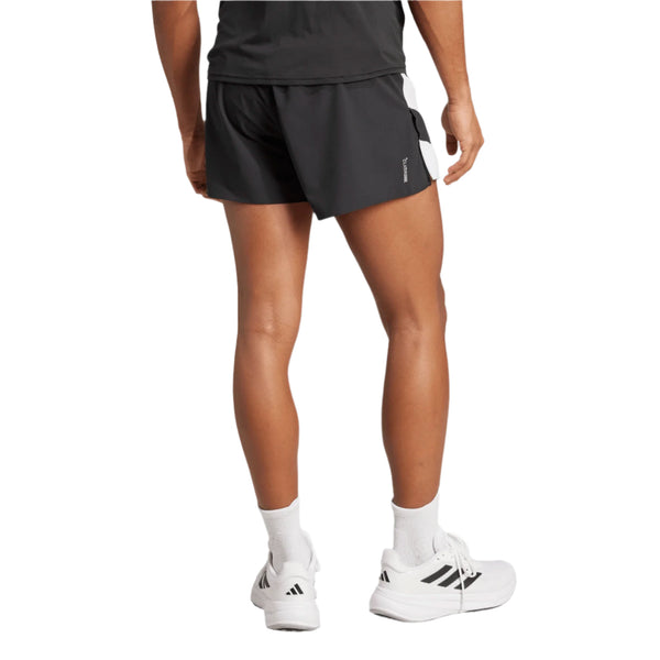 En person står med ryggen til kameraet iført en sort t-shirt, Adizero Archive Gel Shorts 5" i sort fra Adidas, hvide strømper og hvide Adidas-sneakers på en almindelig hvid baggrund.