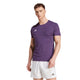 En person ser fremad i en tætsiddende lilla Adizero E Tee, Herre, Aurplu by Adidas med AEROREADY-teknologi og hvide sportsshorts, begge med det lille hvide Adidas-logo. Baggrunden er almindelig hvid.