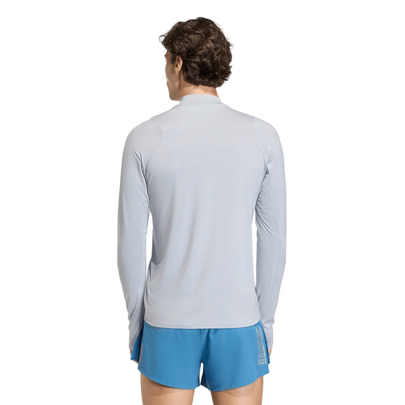 En person med kort brunt hår ses bagfra iført en lysegrå Adidas Adizero Hakone Ekiden Longsleeve, Herre, Halsil og blå shorts på en almindelig hvid baggrund.