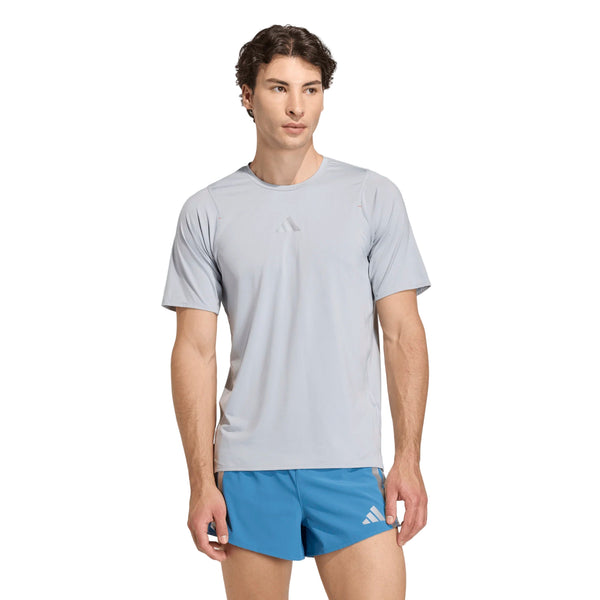 En mand i en lysegrå Adidas Adizero Hakone Ekiden Tee (Herre, Halsil) og blå løbeshorts, begge med små Adidas-logoer, står drejet lidt til venstre mod en almindelig hvid baggrund.