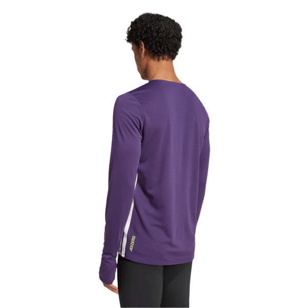 En person med kort krøllet hår ses bagfra iført en langærmet lilla Adidas Adizero L Tee M, Herre, Aurplu skjorte og sorte bukser på en almindelig hvid baggrund.