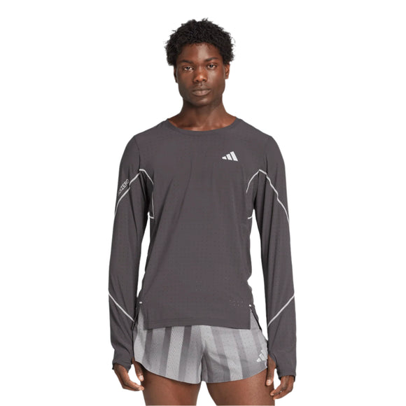 En mand kigger fremad iført en langærmet sort Adidas Adizero P Ls M t-shirt med hvide detaljer og Adidas-logo på brystet og venstre ærme samt gråstribede sportsshorts. Baggrunden er helt hvid.